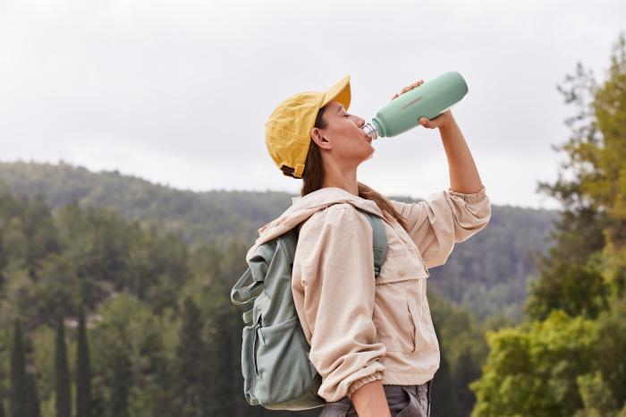 	Kobieta na wycieczce pije z butelki na wodę gazowaną Fizz&Go od SodaStream.